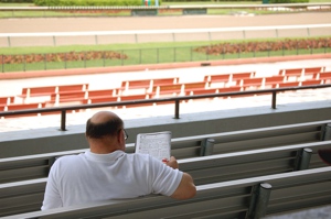 Man at a racetrack putting in his bets