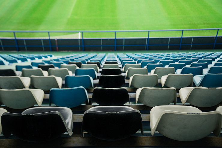 Rows of Empty Stadium Seats and Football Pitch